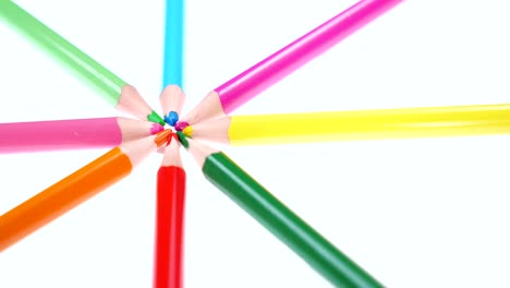 los lápices multicolores de los niños giran sobre un fondo blanco.