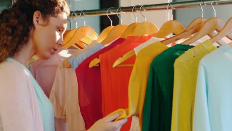 woman choosing clothes from clothes rack