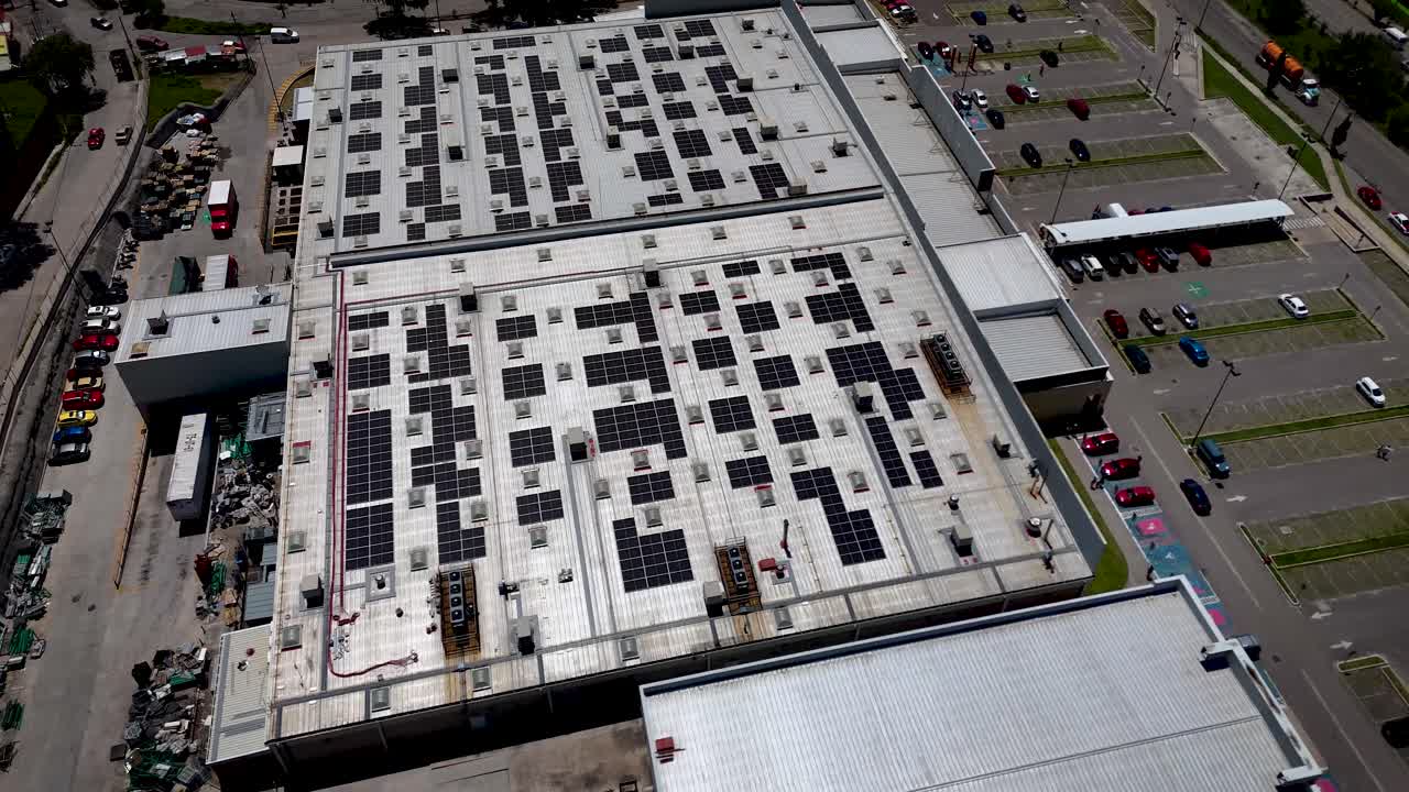 Aerial drone footage flying around a shopping mall with solar panels used for electricity generation in the metropolitan area of Mexico City