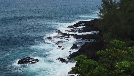 hd 120fps hawaii kauai vista aérea de las olas rompiendo en la costa rocosa que cubre las rocas cercanas, ligero movimiento de izquierda a derecha