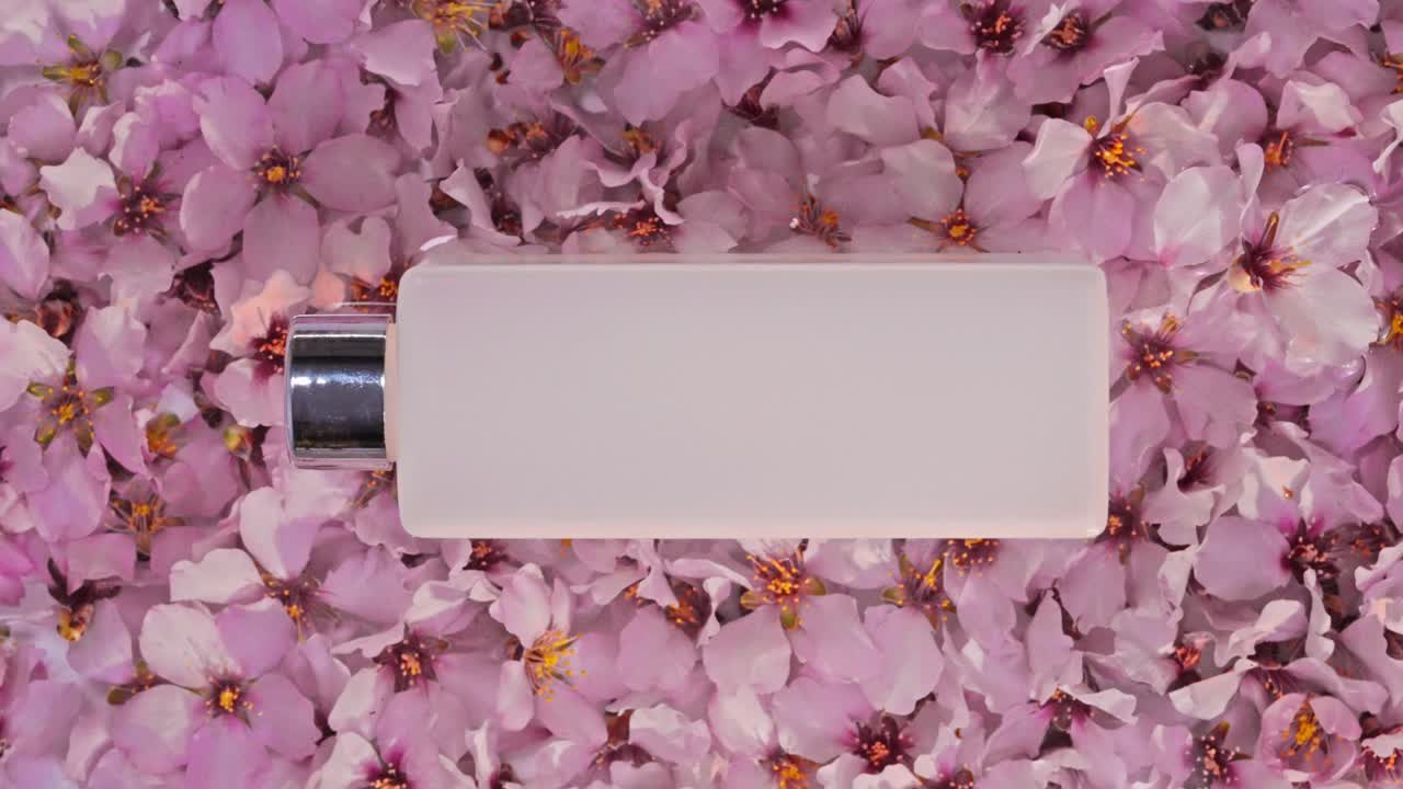 Confezioni cosmetiche su uno sfondo di fiori di mandorlo rosa, effetto onda d'acqua