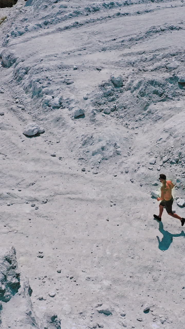 Active runner jogging outdoor. Aerial view of athletic young man running in the nature Vertical video