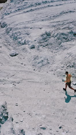 active runner jogging outdoor. aerial view of athletic young man running in the nature vertical video
