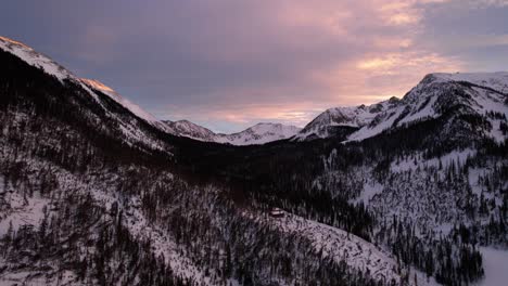 sunset drone view of colorful clouds and a snow covered mountain valley