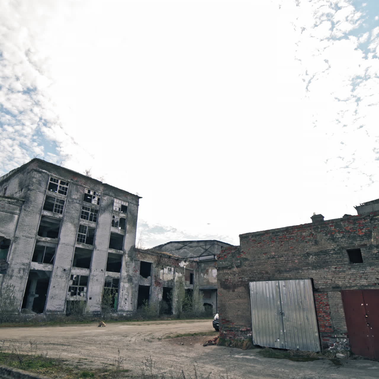 Desolate place with ruined empty buildings outdoors. Gray abandoned buildings without windows after military actions.