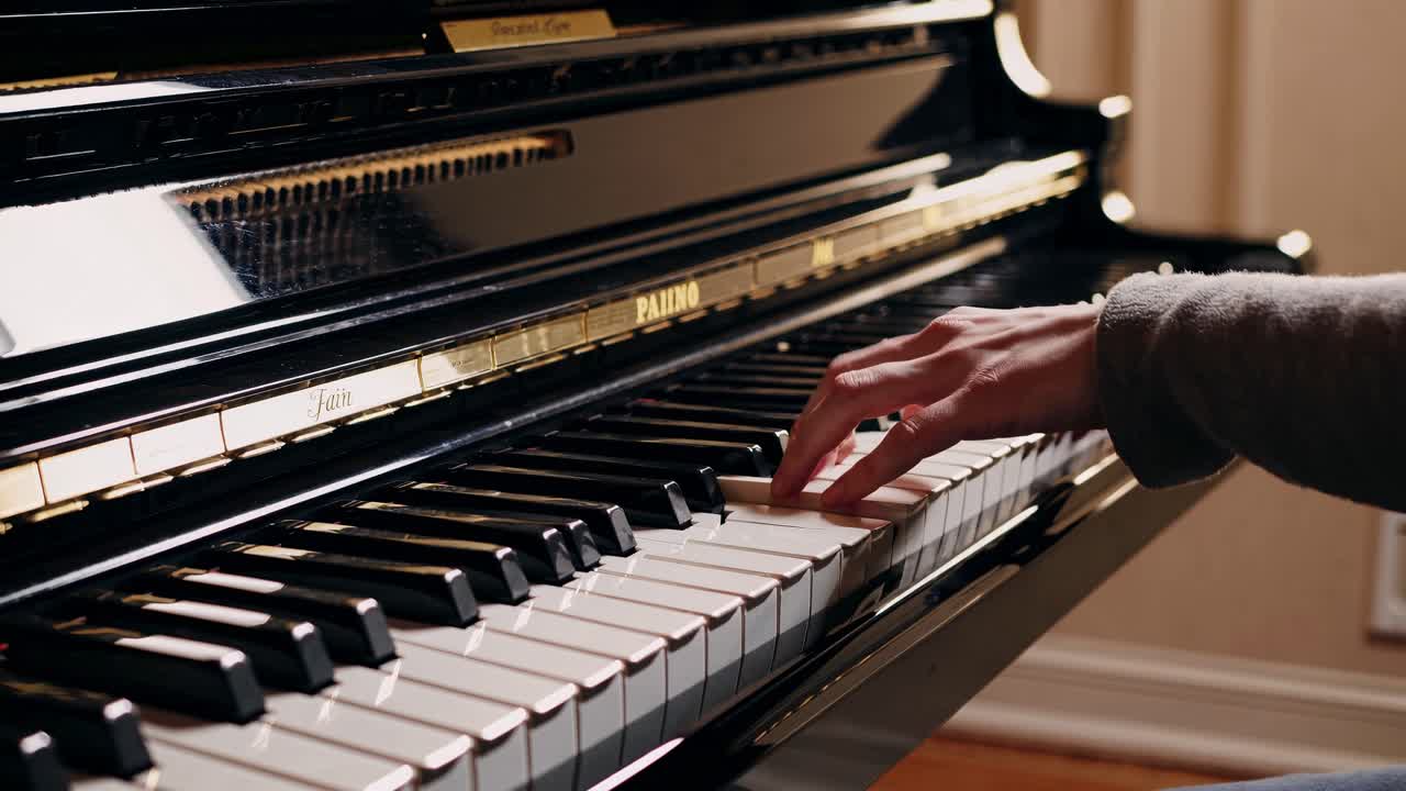 Close-up video of a pianist's hand playing a grand piano, showcasing the elegance and detail
