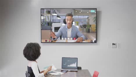 mujer de negocios afroamericana en videollamada con un colega caucásico en la pantalla