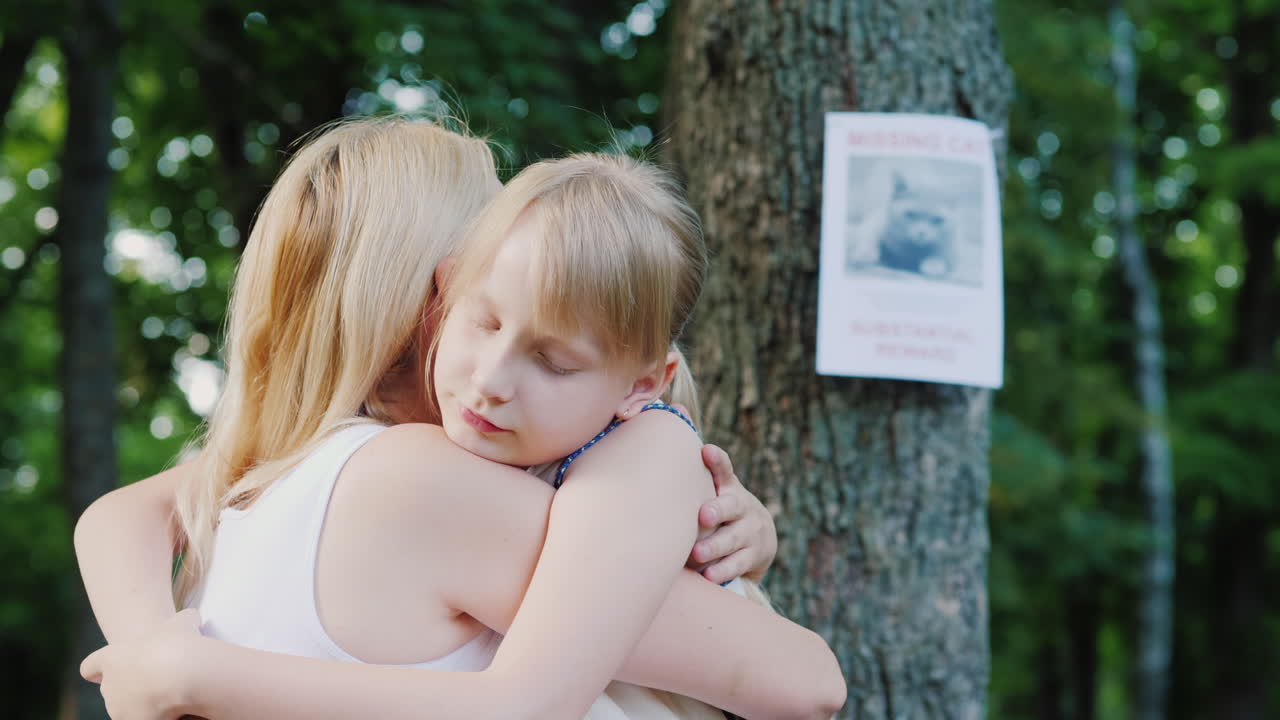 мама успокаивает и обнимает дочь, потерявшую кошку