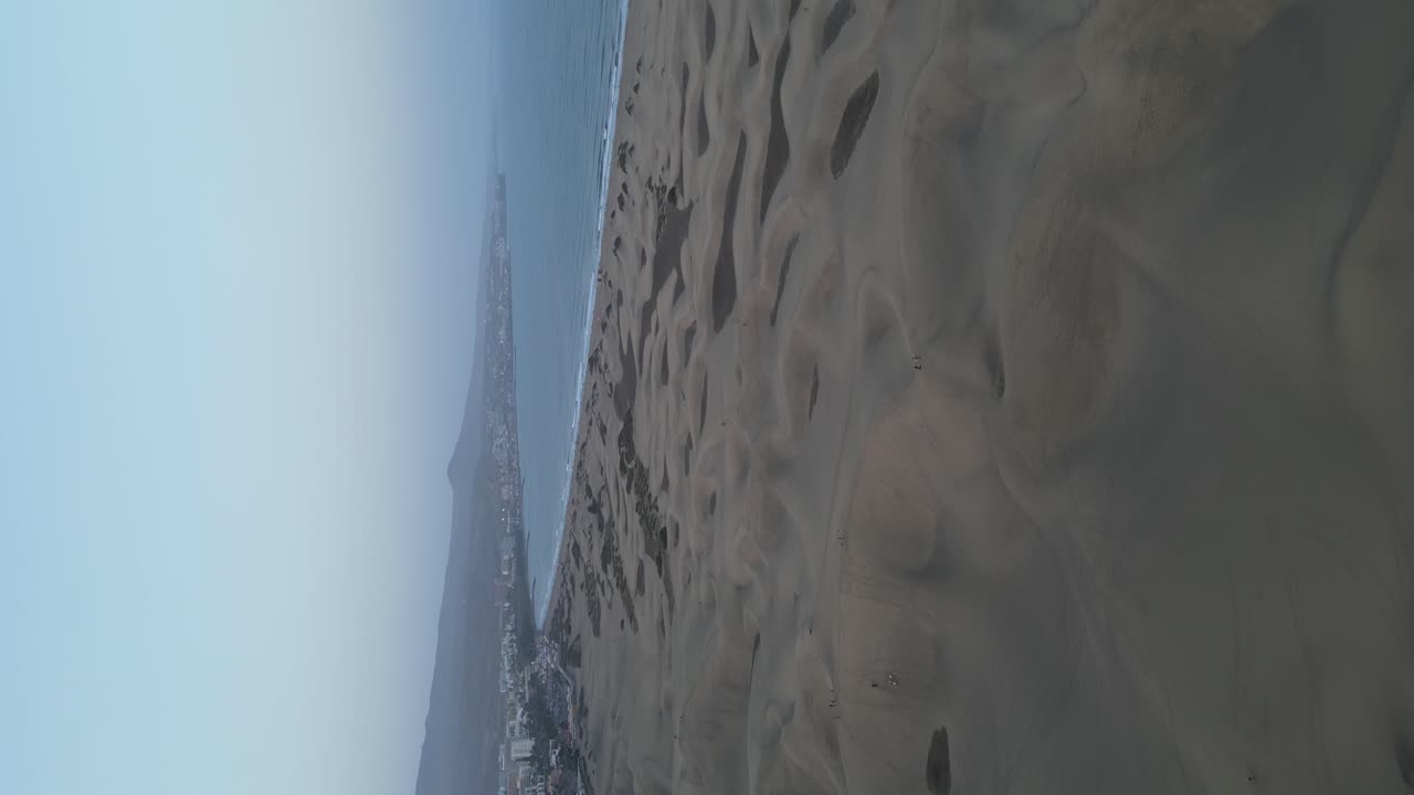 video vertical de dunas de arena de las dunas de maspalomas en la costa de gran canaria al amanecer, orbitando