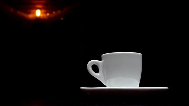 En kop varm kaffe på en sort baggrund med en lampe i baggrunden i 4K-opløsning