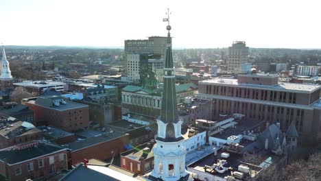 aerial orbit around church steeple in american city during winter sunset