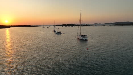 una toma de drone de yates de vela anclados durante la colorida puesta de sol en croacia