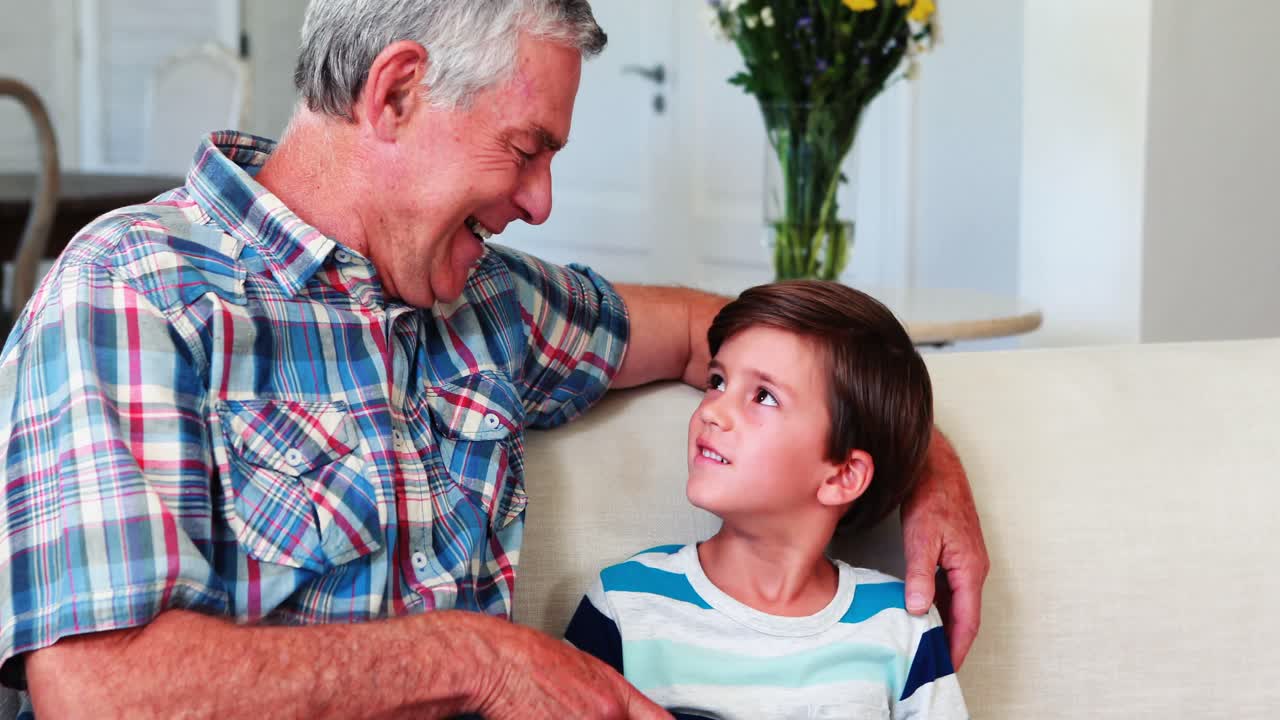 padre y hijo felices usando computadora portátil en la sala de estar