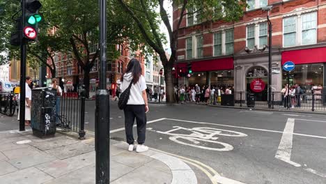 persona que cruza la calle en londres, ciclistas que pasan