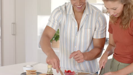 young diverse couple cooking together in kitchen, focusing on preparing meal, at home