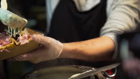 street vendor preparing melted cheese dish