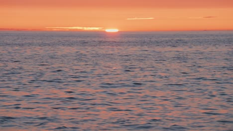 Die-Sonne,-Rot-Wenn-Sie-Untergeht,-Wirft-Einen-Warmen-Schein-Auf-Das-Meer