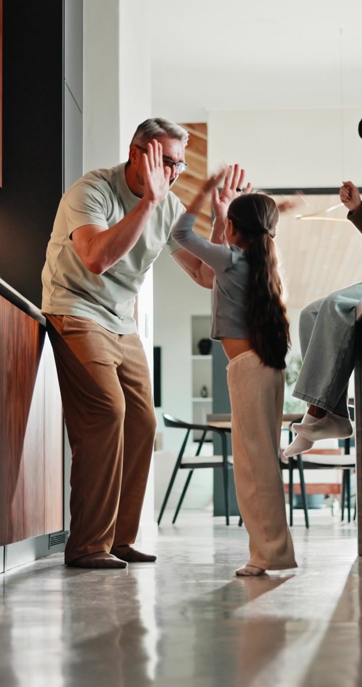 Father and Daughter High Fiving in Modern Kitchen