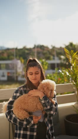 woman cuddling with a poodle outdoors