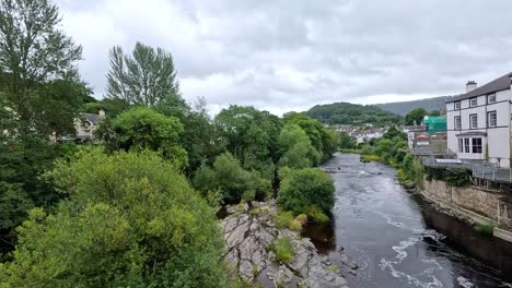 flowing river with lush greenery and buildings