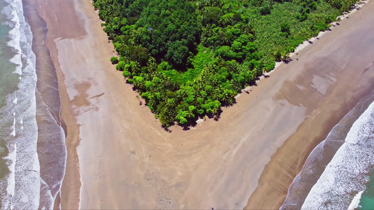 Aerial drone footage revealing a beach shaped like a whale's tail in Ballena Marine National Park, Costa Rica