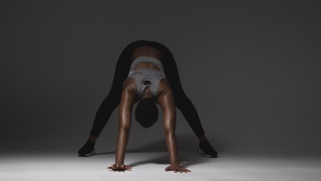 Studio-Shot-Of-Young-Woman-Wearing-Gym-Fitness-Clothing-Warming-Up-For-Exercise-9