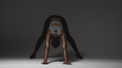 foto de estudio de una mujer joven con ropa de gimnasia calentándose para el ejercicio 9