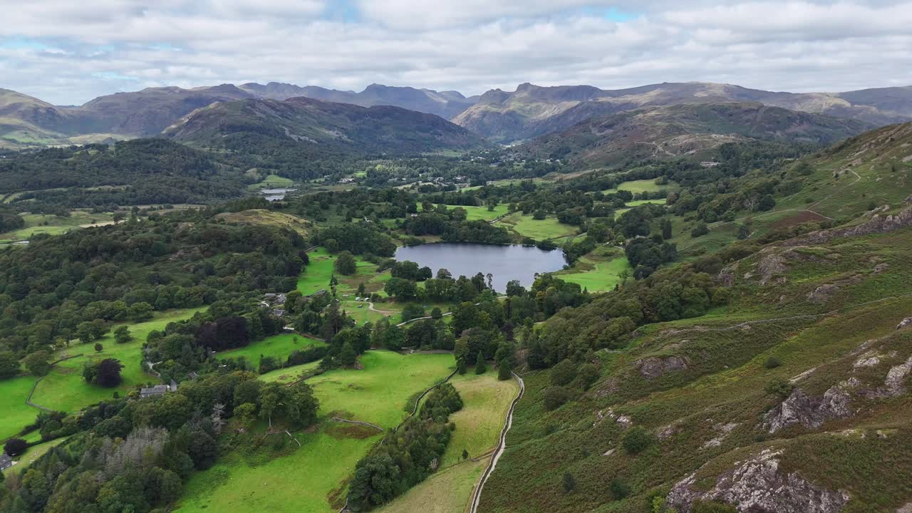 Aerial drone footage capturing sweeping views over Loughrigg Fell in the Lake District on a clear summer’s day
