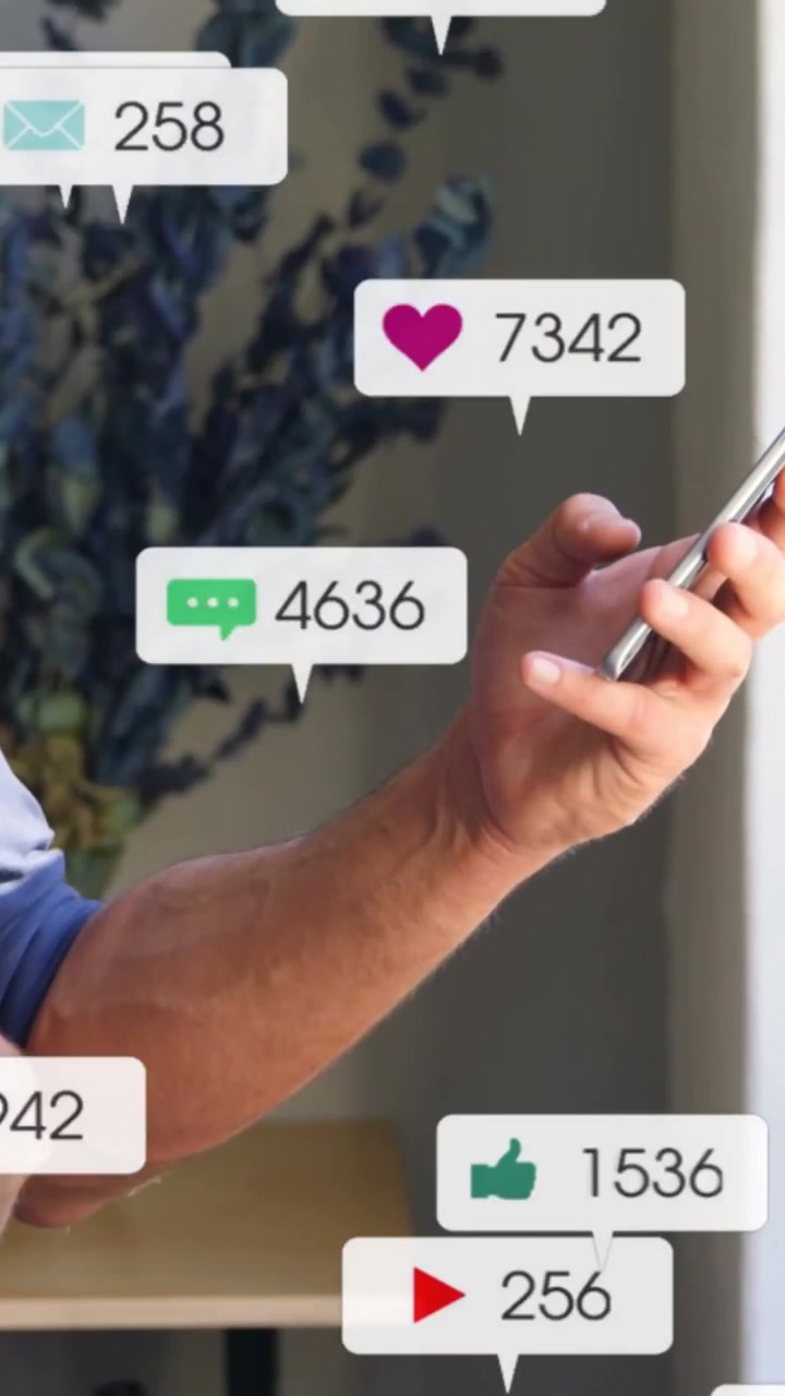 Vertical video: Man holding phone by window, thumb tapping causing social icons tracking engagement
