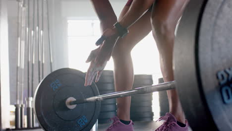 lifting barbell, woman in gym wearing smartwatch preparing for weightlifting exercise