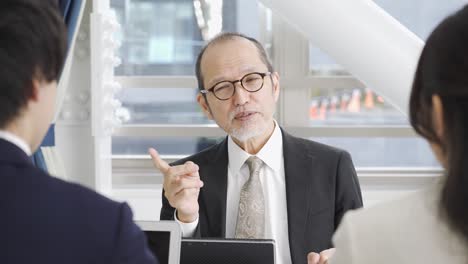 아시아 사업가 한 명이 회의에서 설명하고 있다.