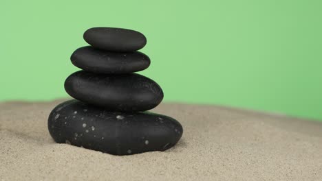 pyramid made of black stones on the sand. rotation. isolated