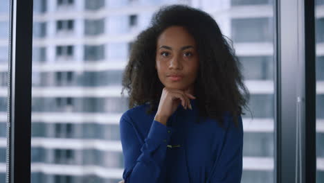 Thoughtful-african-american-executive-woman-looking-camera-in-corporate-office.