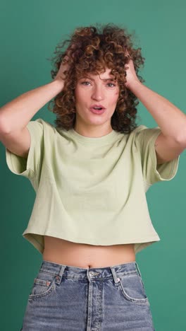 woman surprised on green background. vertical orientation