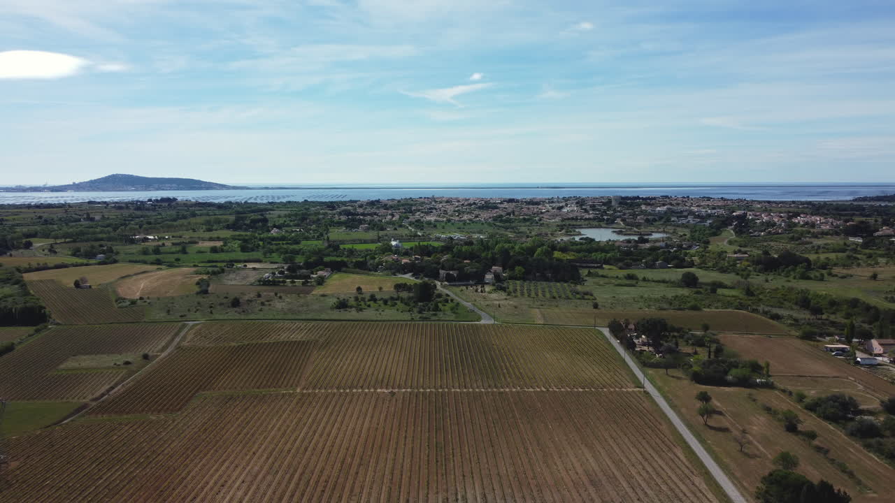 Aerial view of a French countryside with vineyards and a town near the coastline