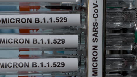 vertical view of research work going on in a lab checking the efficacy of covid vaccines in the market against the new strain b.1.1.529 with samples of it in the tube. omicron rapidly spreading.