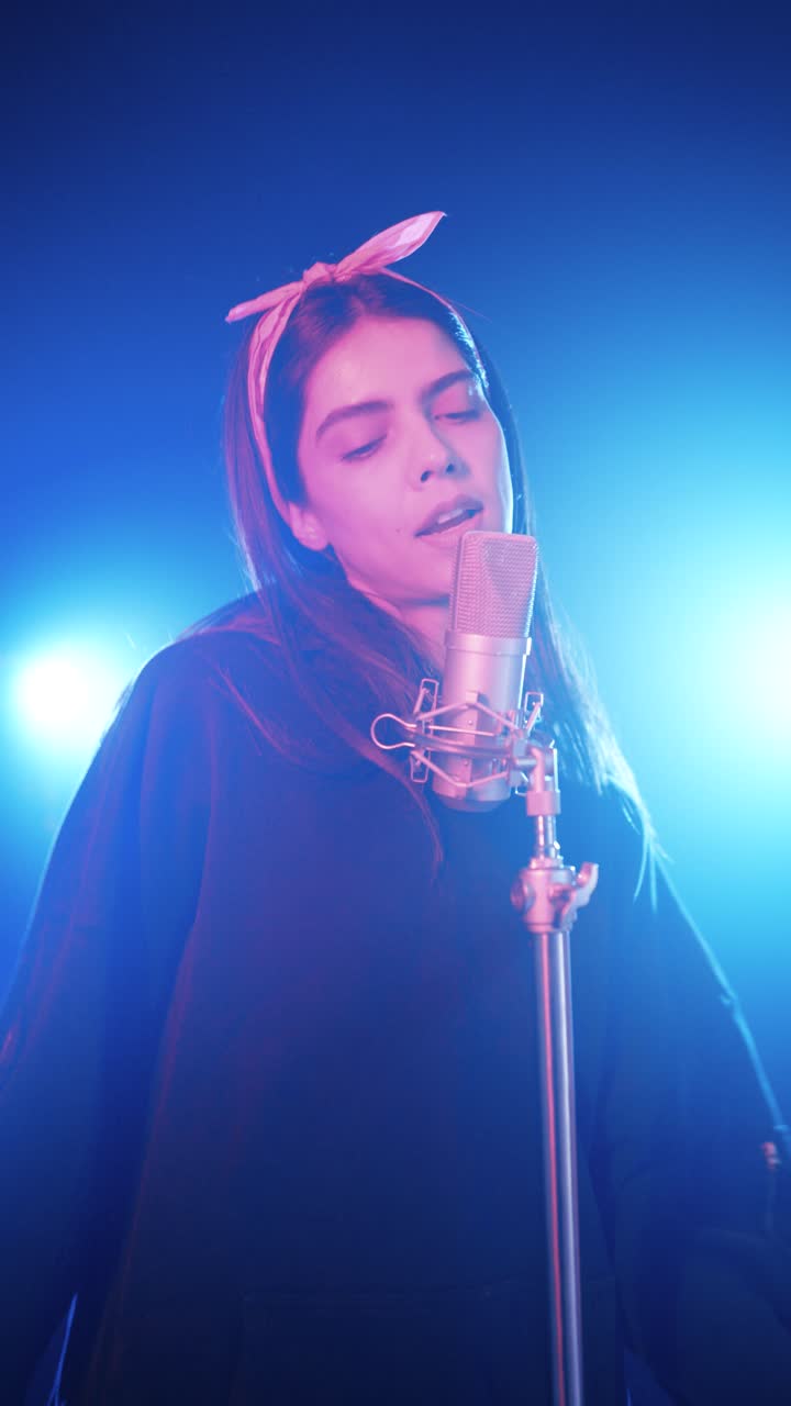 Young latina singer performing in music studio