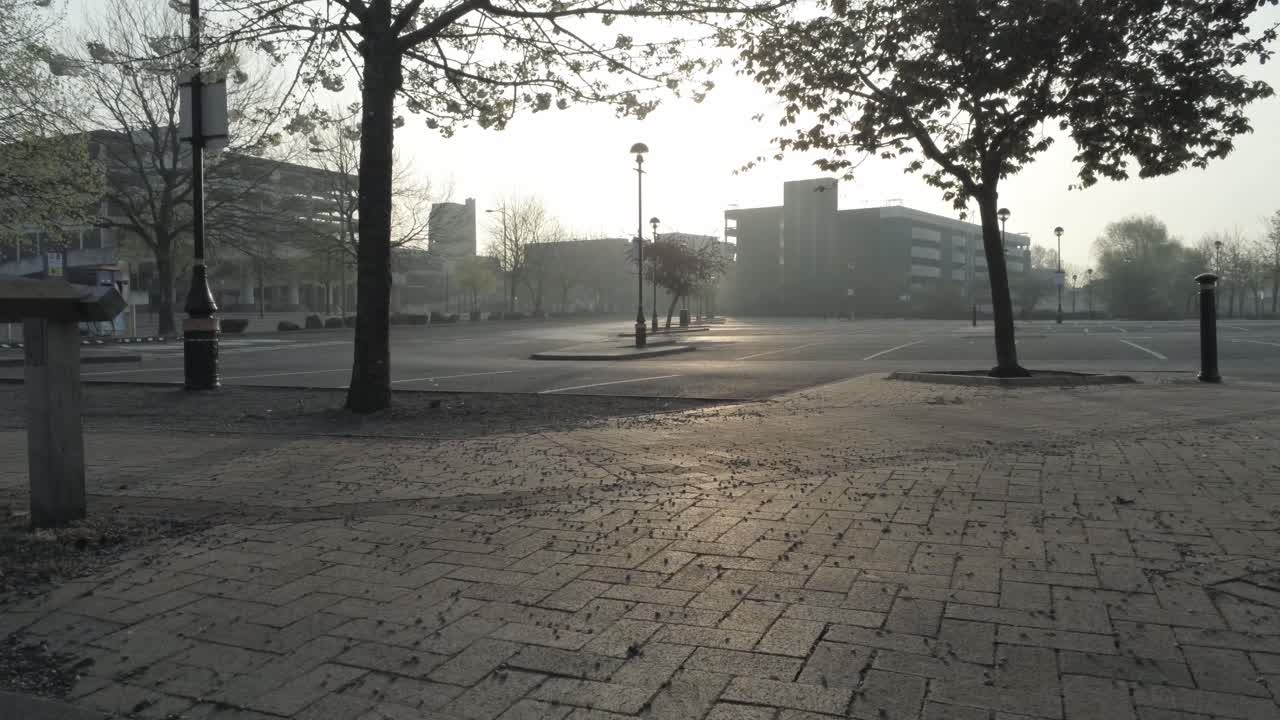 코비드 코로나 바이러스가 일출을 잠그는 동안 빈 마을 주차장을 가로질러 드론 비행 공중 전망