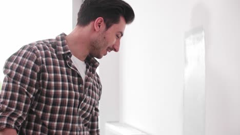 joven pintando la pared interior en un nuevo apartamento