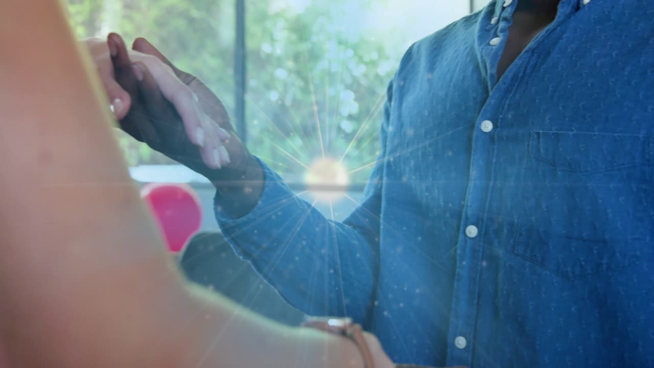 Man taking her hand, offering ring, sliding onto finger, sparkle growing over chest for engagement