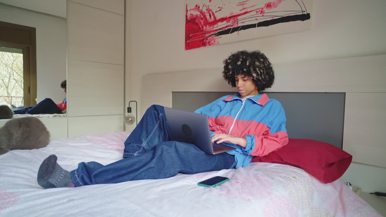 Person working on laptop in bedroom