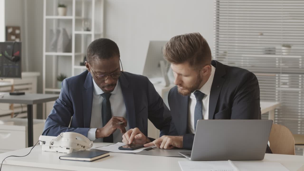 Two Male Brokers Working Together at Stock Exchange Company