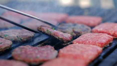 cooked meatball are turning with tongs close up slow motion