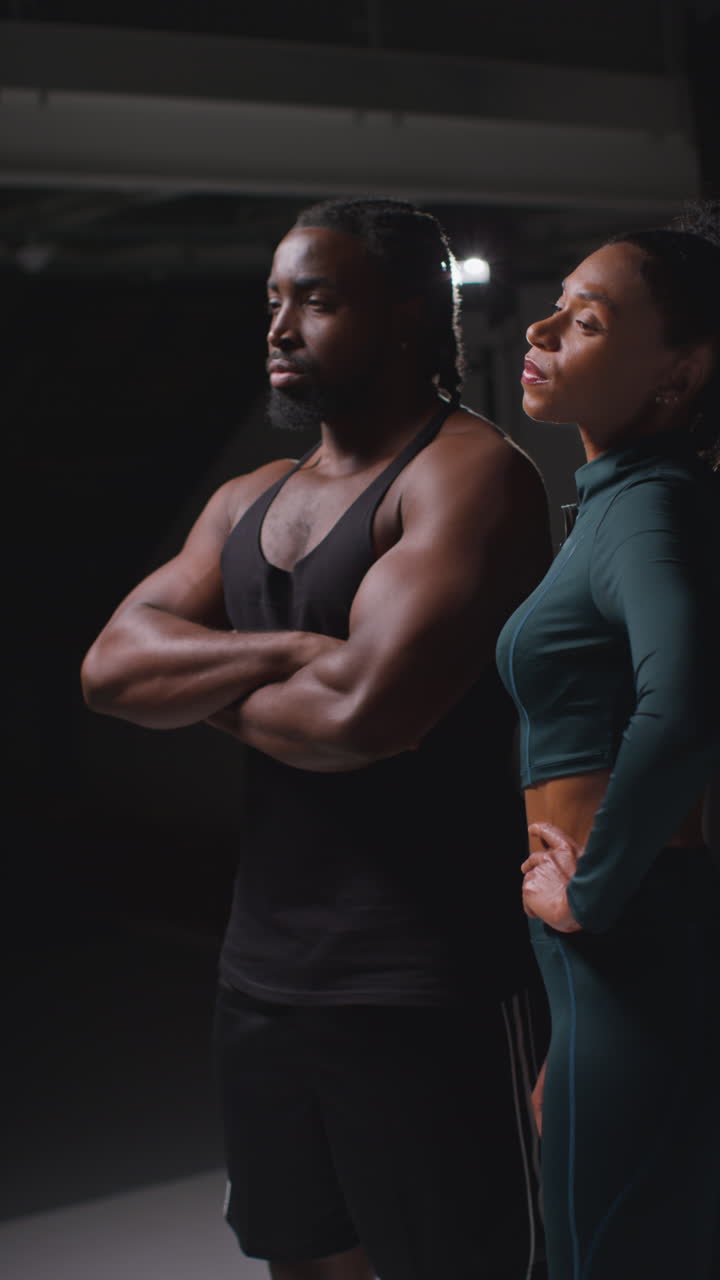 Vertical Video Portrait Of Determined Male And Female Athletes In In Fitness Clothing Shot In Gym With Low Key Lighting 1