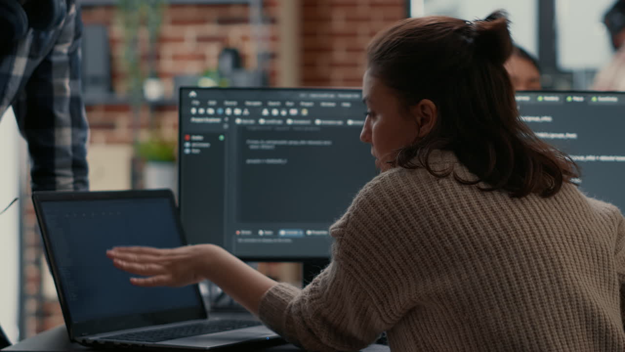 Software programer putting laptop with source code on colleague coder desk asking for opinion