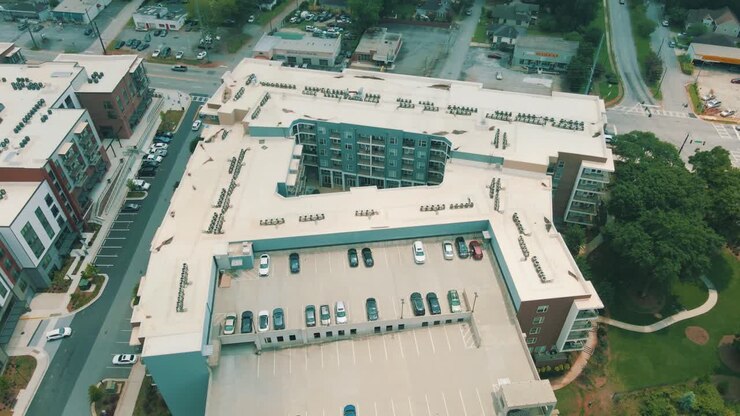 Filmagem de drone oferecendo uma vista única de um complexo de apartamentos com garagem e piscina anexas
