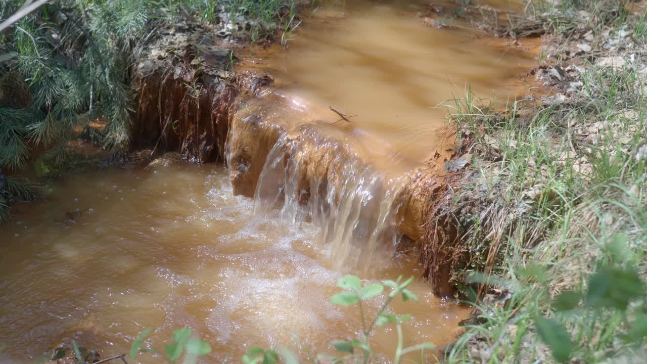 una corriente oxidada que contiene grandes cantidades de hierro y azufre desciende por la cascada para la captura y filtración de partículas