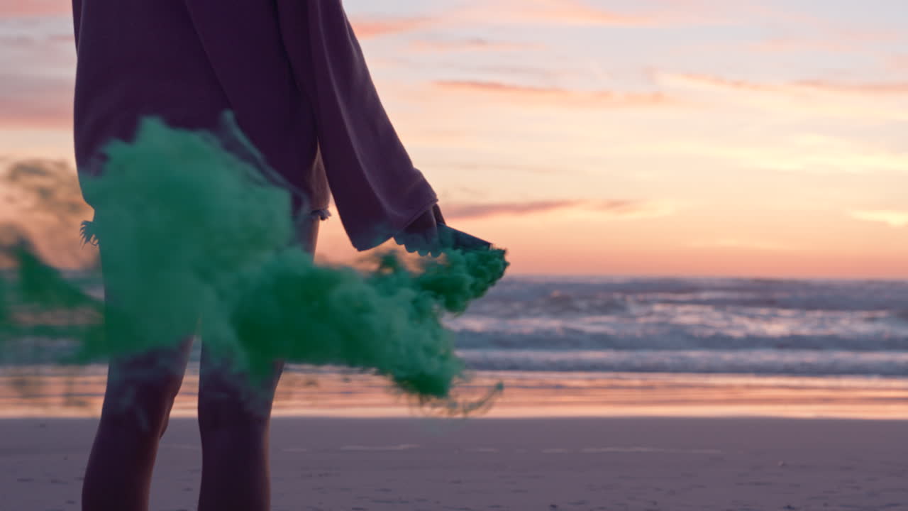 Zonsondergang, strand en vrouw met rookbom