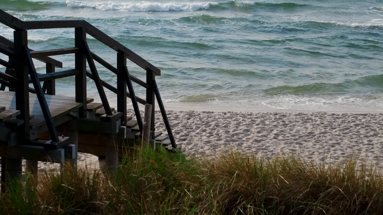 Wooden Stairs Leading to a Sandy Beach with Ocean Waves