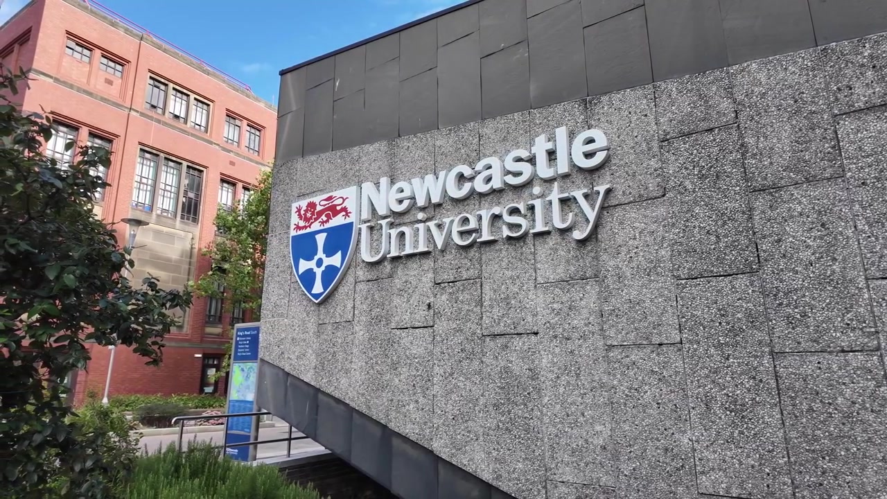 Eingangsschild der Universität Newcastle und Campusgebäude in Newcastle upon Tyne, England